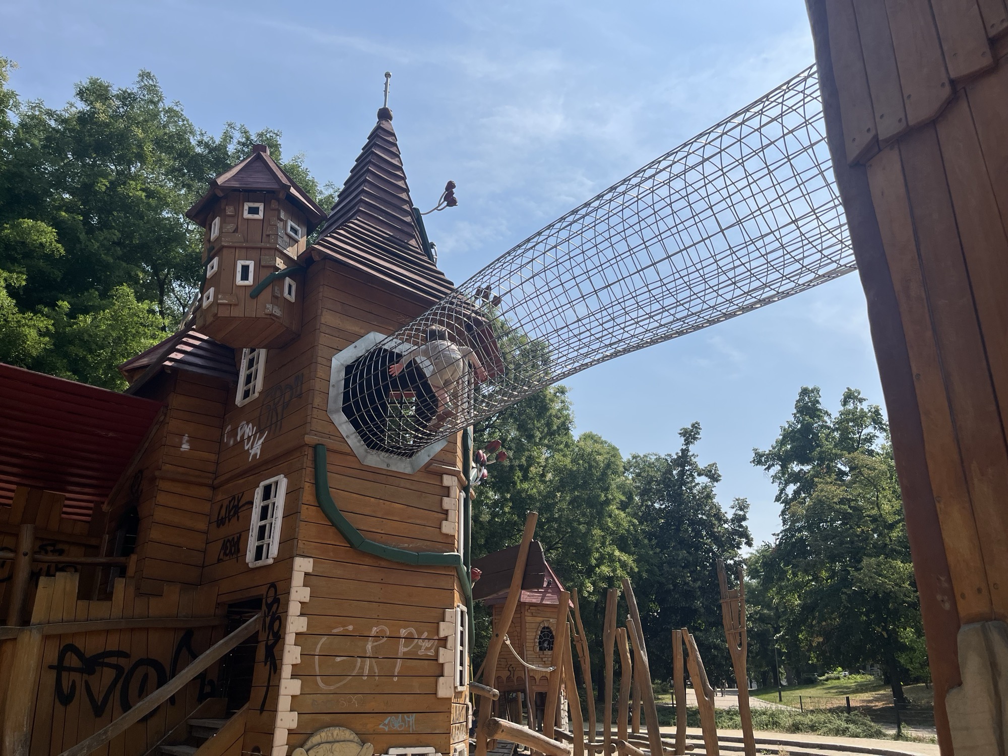 George crawling through the wire-mesh tunnel that bridges two castle towers at the fairytale playground