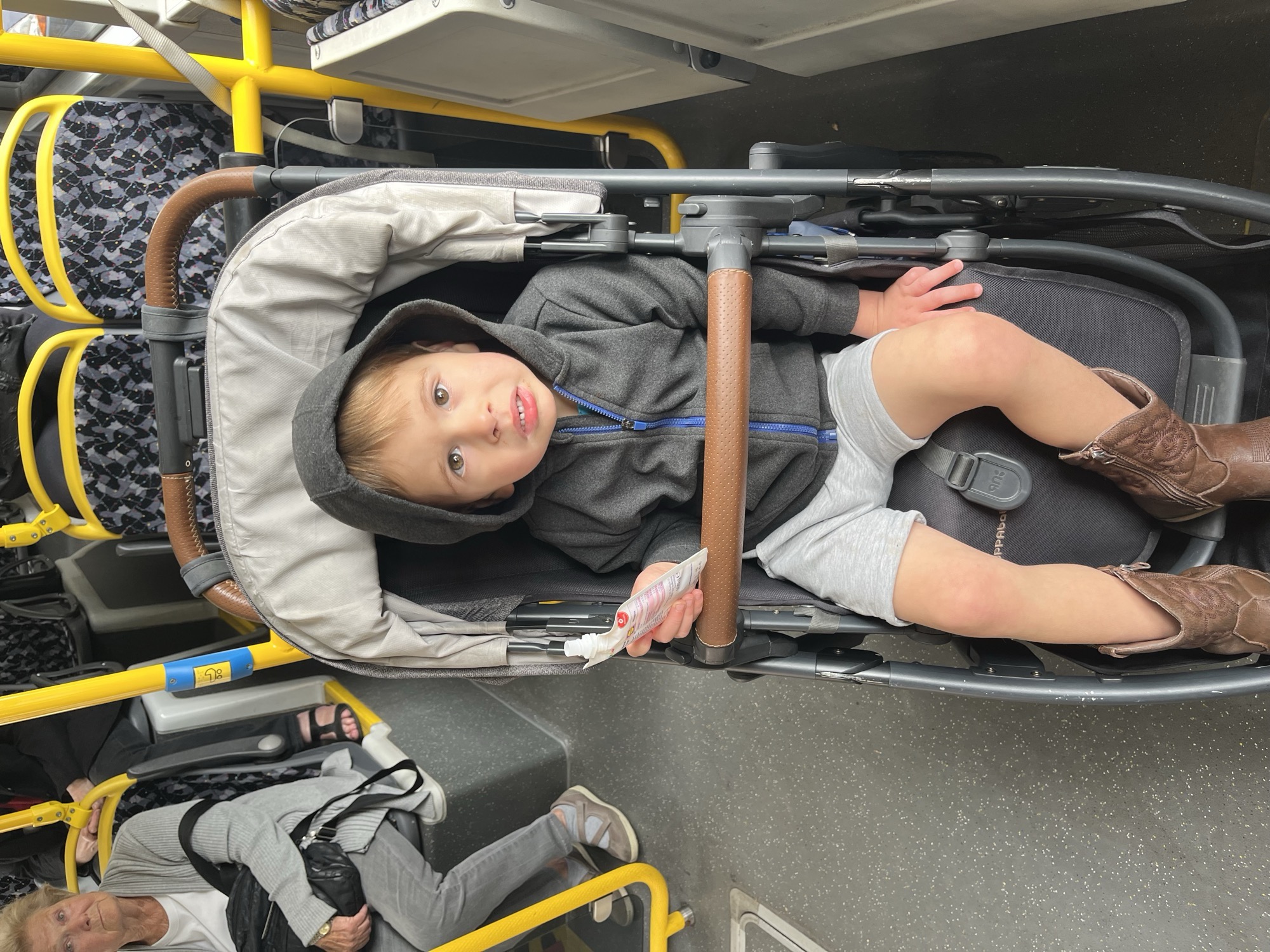 George buckled into his stroller on the bus, snack pouch in hand