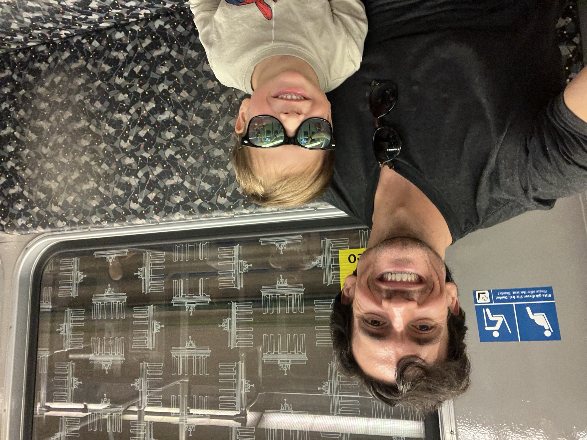 George and me on the U-Bahn, the Brandenburg Gate pattern printed on the windows behind us